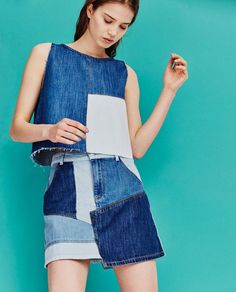 a woman in a denim dress holding a piece of paper