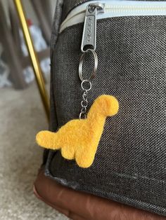 a yellow dog keychain hanging from a backpack