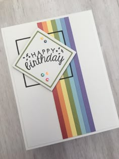 a happy birthday card with a rainbow colored ribbon on the front and back of it