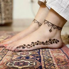 a woman's feet with tattoos on them