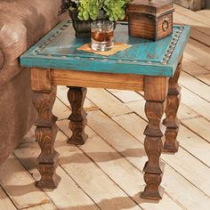 a small table with a potted plant sitting on it's side next to a couch