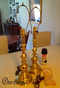 two golden candlesticks sitting on top of a white table