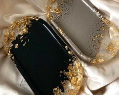 a black and gold case sitting on top of a white bed next to a pillow