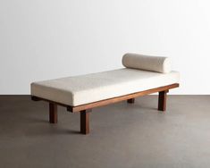 a wooden bench with a white cushion on it