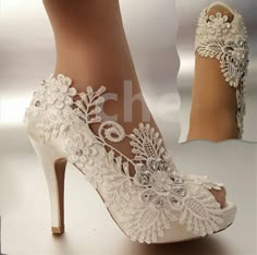 a pair of white high heeled shoes with lace and flowers on the heels are shown