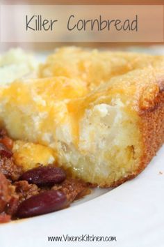 a close up of a piece of bread on a plate with beans and cornbread