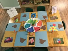 a wooden table topped with lots of paper cut outs and flowers on top of it