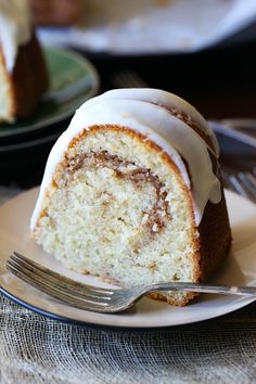 a slice of cinnamon roll on a plate with a fork next to the bundt cake