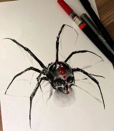 a drawing of a spider sitting on top of a piece of paper next to two markers