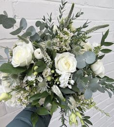 a bouquet of white roses and greenery