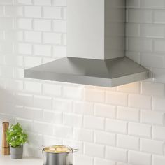 a stove top oven sitting next to a pot filled with food on a kitchen counter