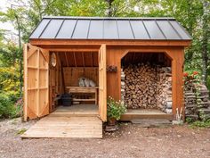 a small wooden shed with logs stacked in it