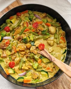 a pan filled with vegetables and meat on top of a table