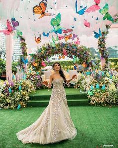 a woman in a wedding dress is posing for the camera with butterflies on her head