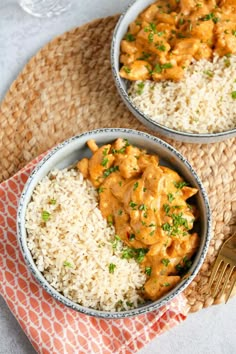 two bowls filled with rice and chicken on top of a mat next to a fork