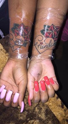 two girls with matching tattoos on their arms and hands holding each other's hands