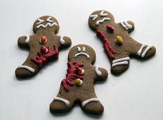 three decorated ginger cookies sitting on top of a table