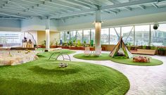 an indoor play area with lots of green grass