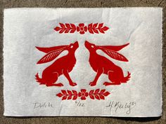 a red and white towel with two foxes on it