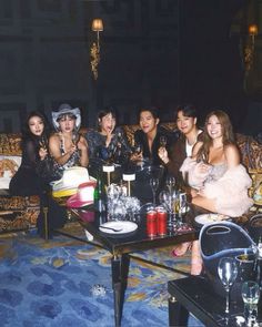 a group of people sitting on top of a couch in front of a table filled with drinks