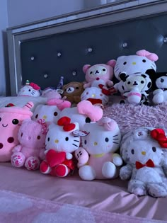 a bunch of hello kitty stuffed animals on a bed