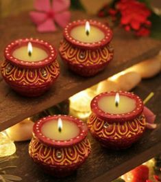 three red candles sitting on top of a wooden table