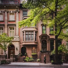 an old brownstone building with many windows and steps leading up to the front door