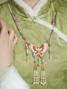 Add a touch of Ming Dynasty embroidery to any outfit with this stunning necklace! Colorful handmade double-sided butterfly, adorned with various golden charms and dainty pearls. Various colored beads add dimension and allow this accessory to be paired with a variety of colors and dynasties. Choose from a lovely rose or mountain green shade to best suit your aesthetic. Materials: Rose colored resin, petrified aquamarine, imitation white agate, imitation pearls, silk tassel, polyester embroidered Gold Beaded Butterfly Necklace Gift, Gold Beaded Butterfly Necklace For Gift, Gold Beaded Butterfly Necklace Perfect As Gift, Otherworldly Beauty, Cloud Necklace, Modern Hanfu, Necklace Colorful, Embroidered Butterfly, White Agate