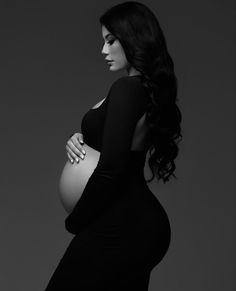 a pregnant woman poses for a black and white photo