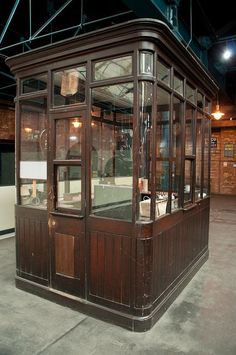 an old - fashioned glass and wood display case in the middle of a building at night