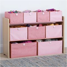 pink storage bins on top of a wooden shelf