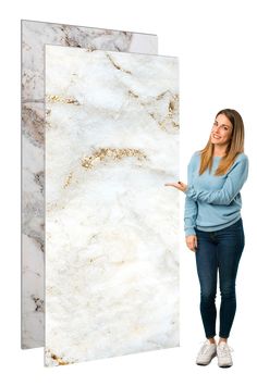 a woman standing next to a white marble wall with her hand on the door and pointing at it