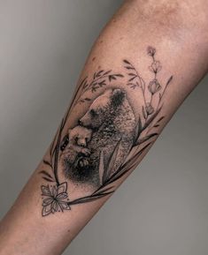 a black and white tattoo on the arm of a person with a bear in it