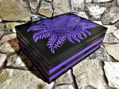 a purple and black box sitting on top of a stone floor