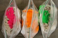 three bags filled with different colored powders