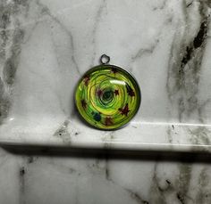 Original art of a green galaxy on a round pendant. Handmade and unique, by artist Rachel Raynor. This listing is for the pendant only. Pendant is stainless steel and glass, 25mm wide. Artistic Round Cabochon Jewelry, Green Hand Painted Spiritual Jewelry, Hand Painted Green Spiritual Jewelry, Spiritual Hand Painted Green Jewelry, Green Circular Jewelry Gift, Artistic Green Round Pendant Necklace, Green Nickel-free Artsy Jewelry, Green Round Large Pendant Jewelry, Artistic Green Nickel-free Jewelry