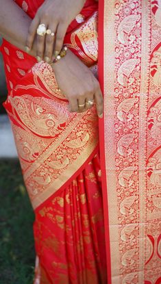 a woman wearing a red and gold sari