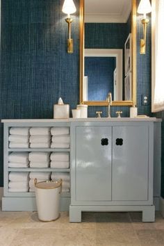 a bathroom with blue walls and white cabinets