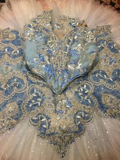 a heart shaped blue and silver piece of cloth with sequins on the edges