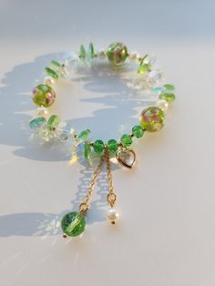 This beautiful green bracelet is very suitable for daily wear. It can also be given to girlfriends, daughters, mothers, or as a birthday gift to friends Main materials: Beads Size: My bracelets are elastic bracelets, the size of the bracelets is a little under 6.5inches without stretching, so they can be suitable for most people's wrist. It is elastic so if you need a bigger size, it is important to consider that it does stretch. Green Heart Beads Bracelet Jewelry, Green Heart Beads Bracelet, Green Jewelry With Heart Charm And Round Beads, Dainty Adjustable Green Pearl Bracelet, Adjustable Green Charm Bracelet With Colorful Beads, Green Adjustable Charm Bracelet With Colorful Beads, Adjustable Green Heart-shaped Beaded Bracelets, Elegant Green Charm Bracelet With Round Beads, Fairy Core Bracelets