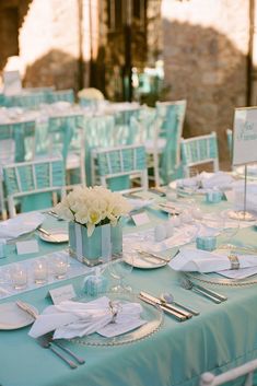 the table is set with white flowers and place settings for an elegant dinner or reception