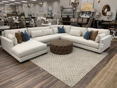 a living room filled with furniture and lots of pillows on top of a wooden floor