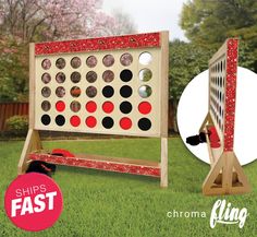 an image of a giant board game in the grass with red and black dots on it