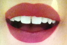 a woman's mouth with white teeth and red lipstick