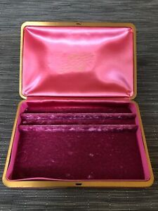 an open pink and gold box on a table