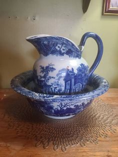 a blue and white pitcher sitting on top of a bowl