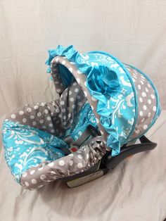 a baby car seat with blue and white polka dots on it's back cover