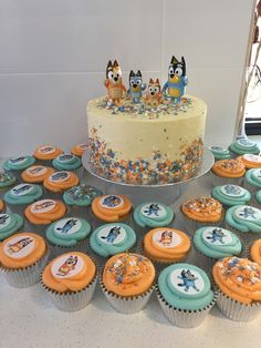 a table topped with lots of cupcakes covered in frosting