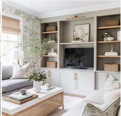 a living room filled with furniture and a flat screen tv on top of a wooden shelf