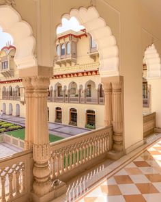 the inside of a building with many arches and pillars on both sides, looking out onto a courtyard